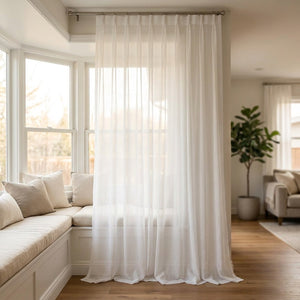 Voilage blanc mousseline taille 300 x 250 cm devant une grande baie vitrée avec banquette