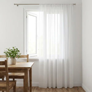 Voilage blanc transparent en tulle devant une fenêtre de coin repas avec table en bois
