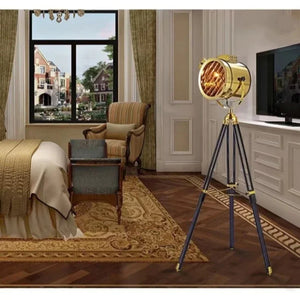 Lampadaire projecteur trépied doré dans chambre