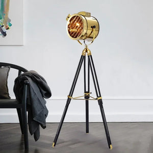 Lampadaire projecteur trépied doré dans salon moderne
