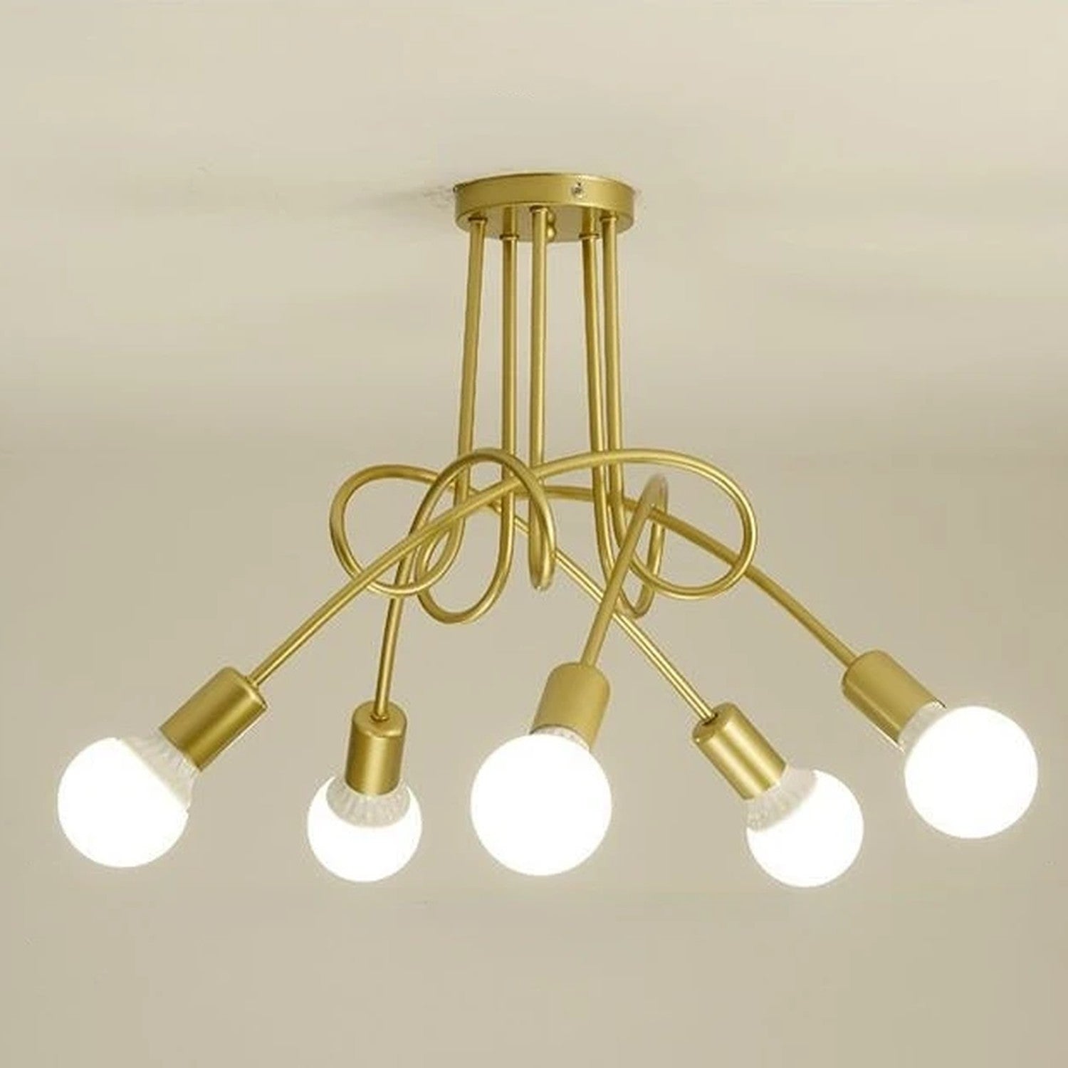 Lustre 5 bras doré torsadés avec ampoules allumées au plafond