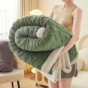 Une couverture lestée texturée en jacquard sherpa, épaisse et moelleuse, présentée en plusieurs coloris vert, tenue dans les bras pour montrer son aspect cocooning et enveloppant.