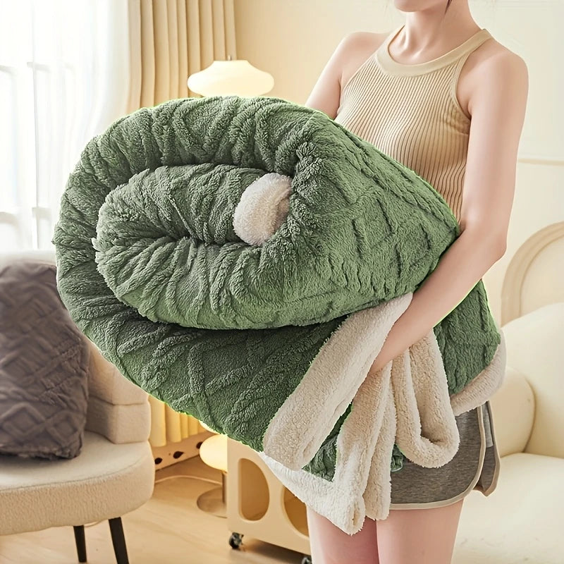 Une couverture lestée texturée en jacquard sherpa, épaisse et moelleuse, présentée en plusieurs coloris vert, tenue dans les bras pour montrer son aspect cocooning et enveloppant.