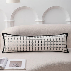 Photo du traversin motif quadrillé noir sur canapé bouclette beige