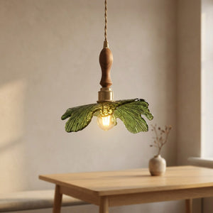 Suspension feuille en verre vert et bois de noyer allumée au-dessus d'une table