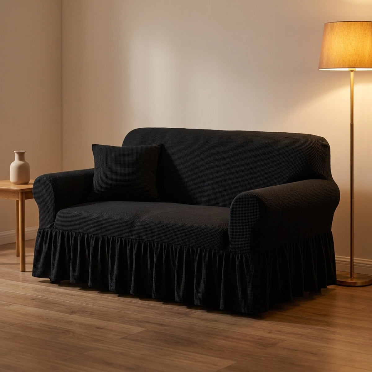 Housse de canapé noire à volant dans un salon cocooning en soirée avec lampadaire