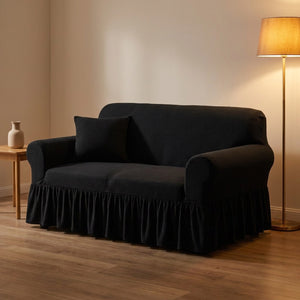 Housse de canapé noire à volant dans un salon cocooning en soirée avec lampadaire