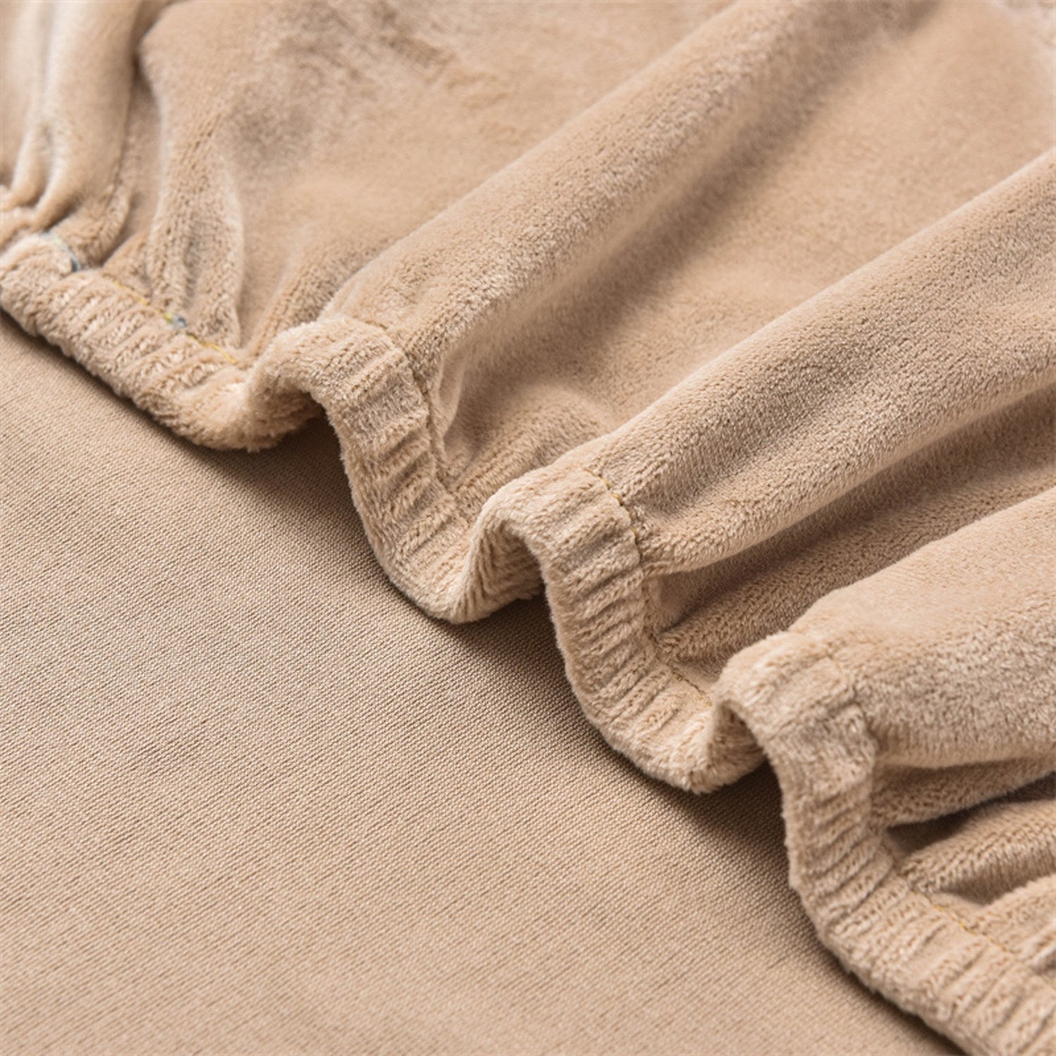 Détail du tissu velours extensible doux au toucher de la housse de fauteuil club