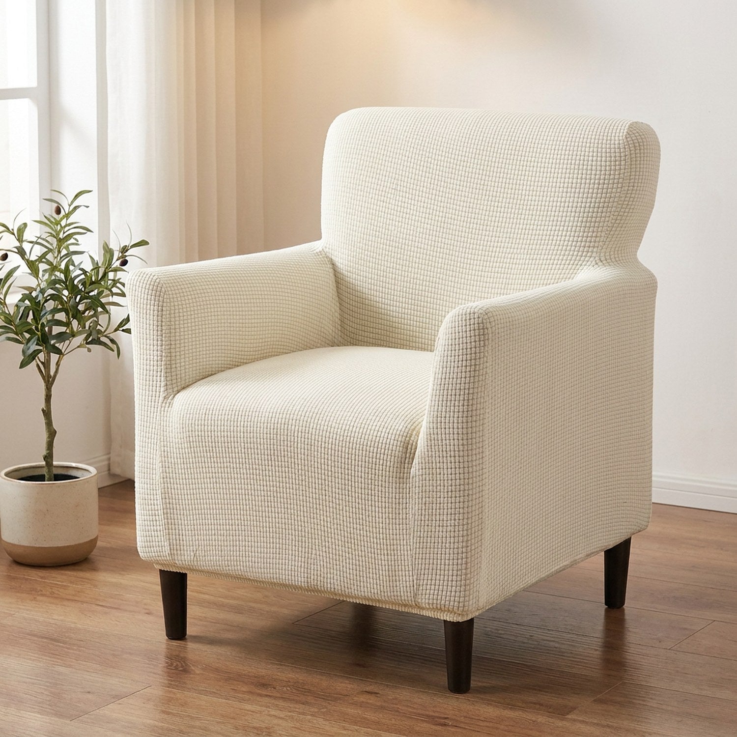 Fauteuil habillé d'une housse jacquard blanc cassé dans un salon lumineux