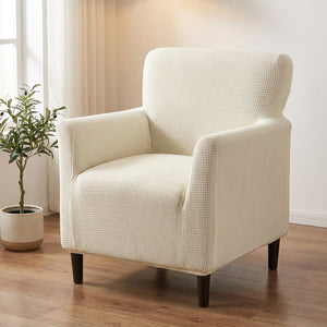 Fauteuil habillé d'une housse jacquard blanc cassé dans un salon lumineux