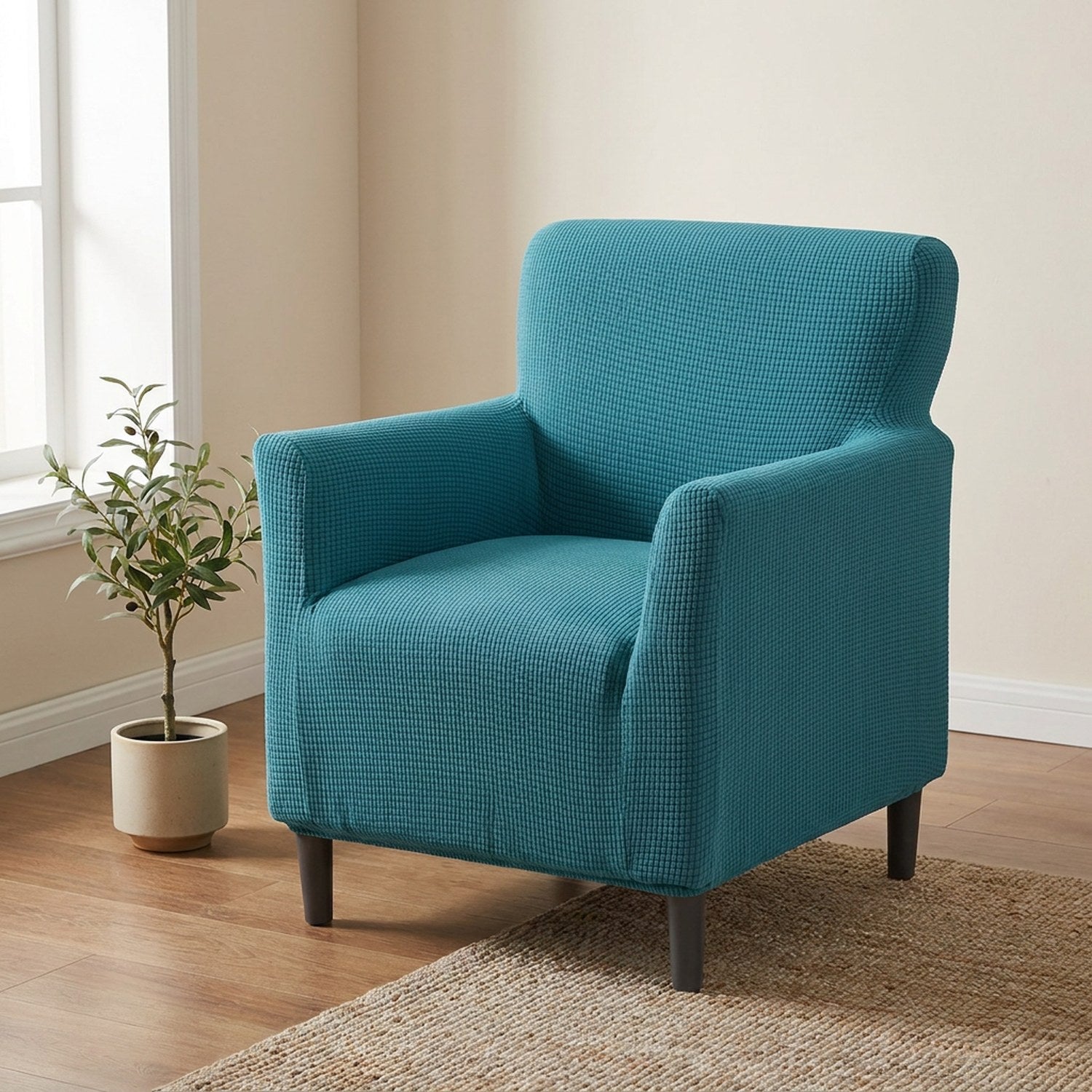 Fauteuil habillé d'une housse jacquard bleu canard dans un salon lumineux