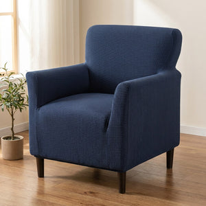 Fauteuil habillé d'une housse jacquard bleu marine dans un salon lumineux