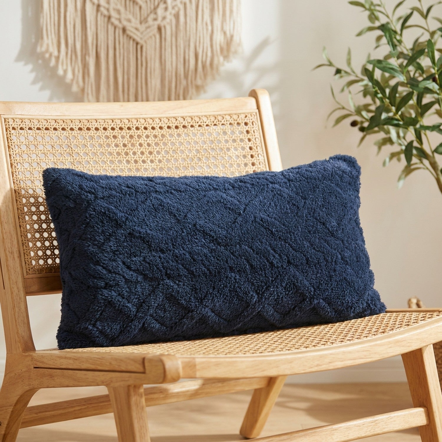 Housse de coussin lombaire en peluche bleu marine à relief géométrique sur un fauteuil en bois
