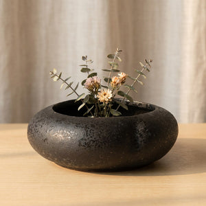 Vase galet en céramique noire avec fleurs séchées