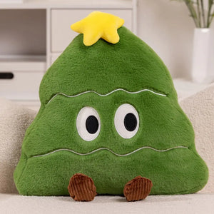 Un coussin Noël sapin mignon décoratif en forme de sapin avec un visage expressif et une étoile au sommet, posé sur un canapé dans un salon lumineux.