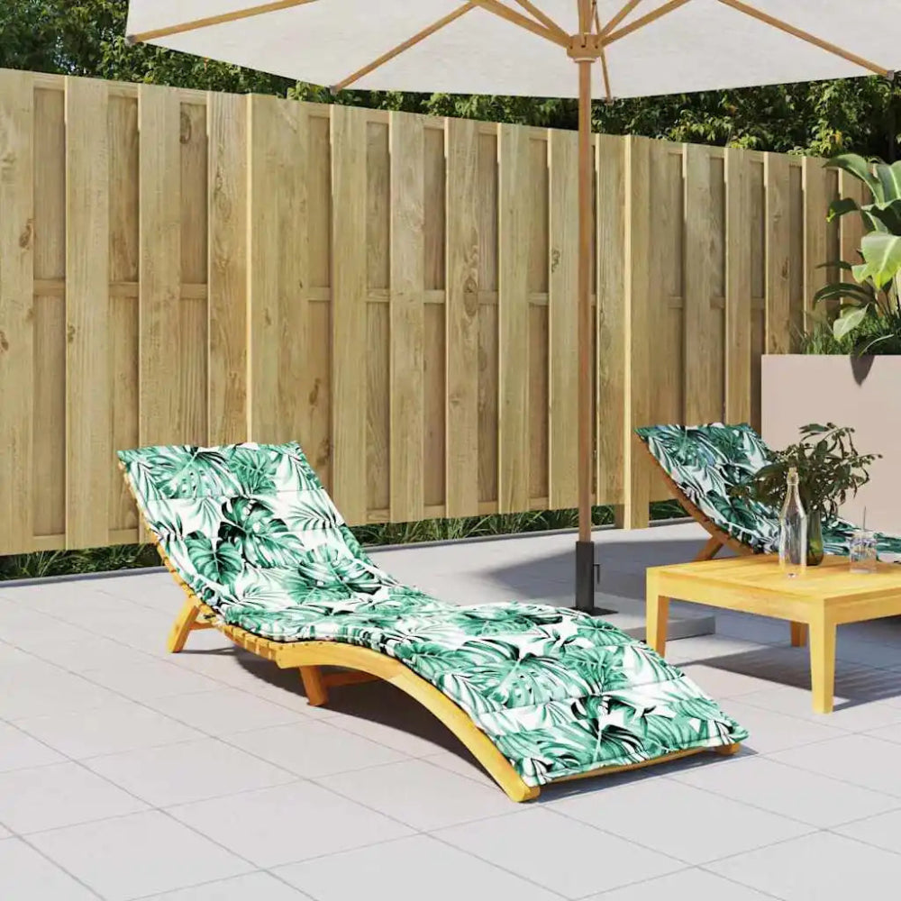 Coussin bain de soleil confortable avec motif végétal installé sur un transat en bois, placé sur une terrasse extérieure sous un parasol, créant un espace détente lumineux et accueillant.