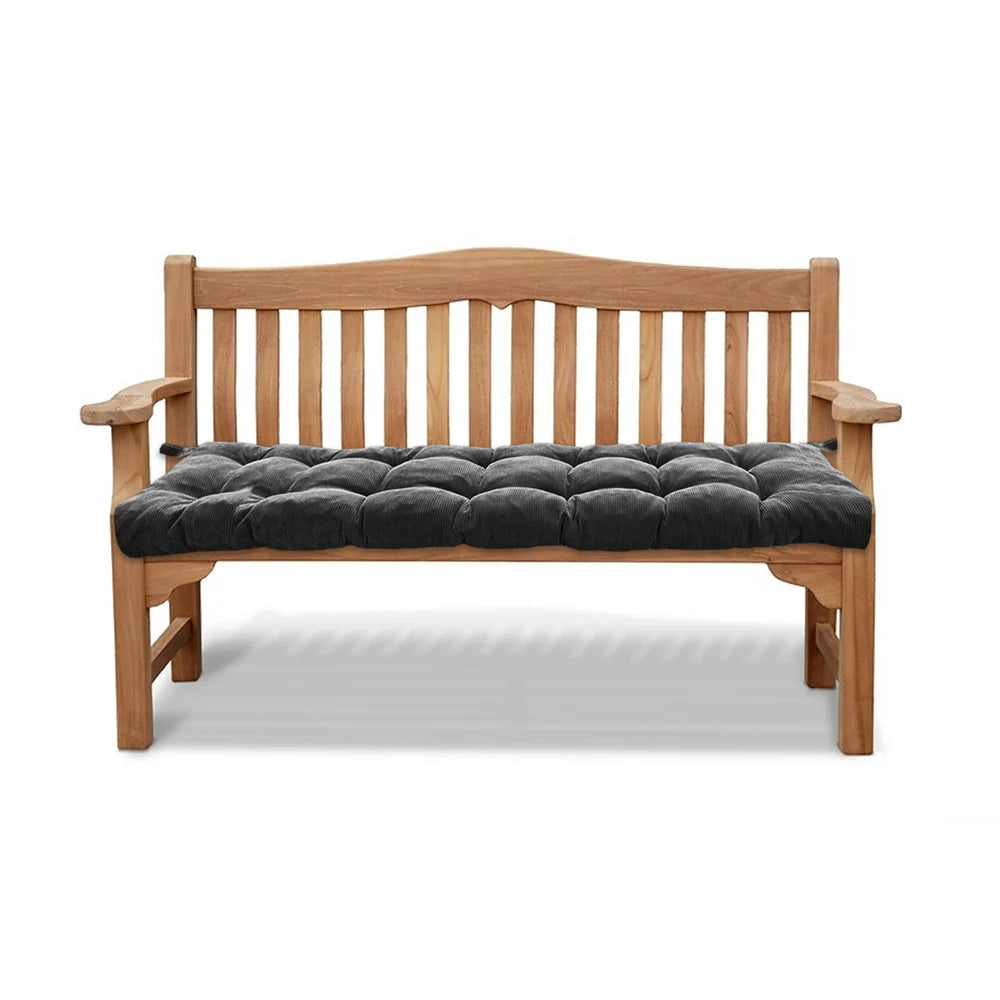 Un coussin banc en velours côtelé capitonné installé sur un banc en bois avec dossier et accoudoirs, offrant une assise épaisse et confortable.