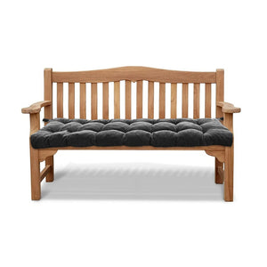 Un coussin banc en velours côtelé capitonné installé sur un banc en bois avec dossier et accoudoirs, offrant une assise épaisse et confortable.