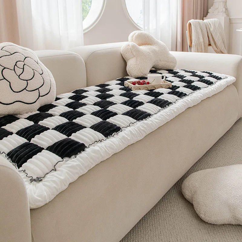 Un coussin chat cocooning épais posé sur un canapé, avec une surface matelassée formant un large espace moelleux où un chat peut s’allonger confortablement pour se reposer.
