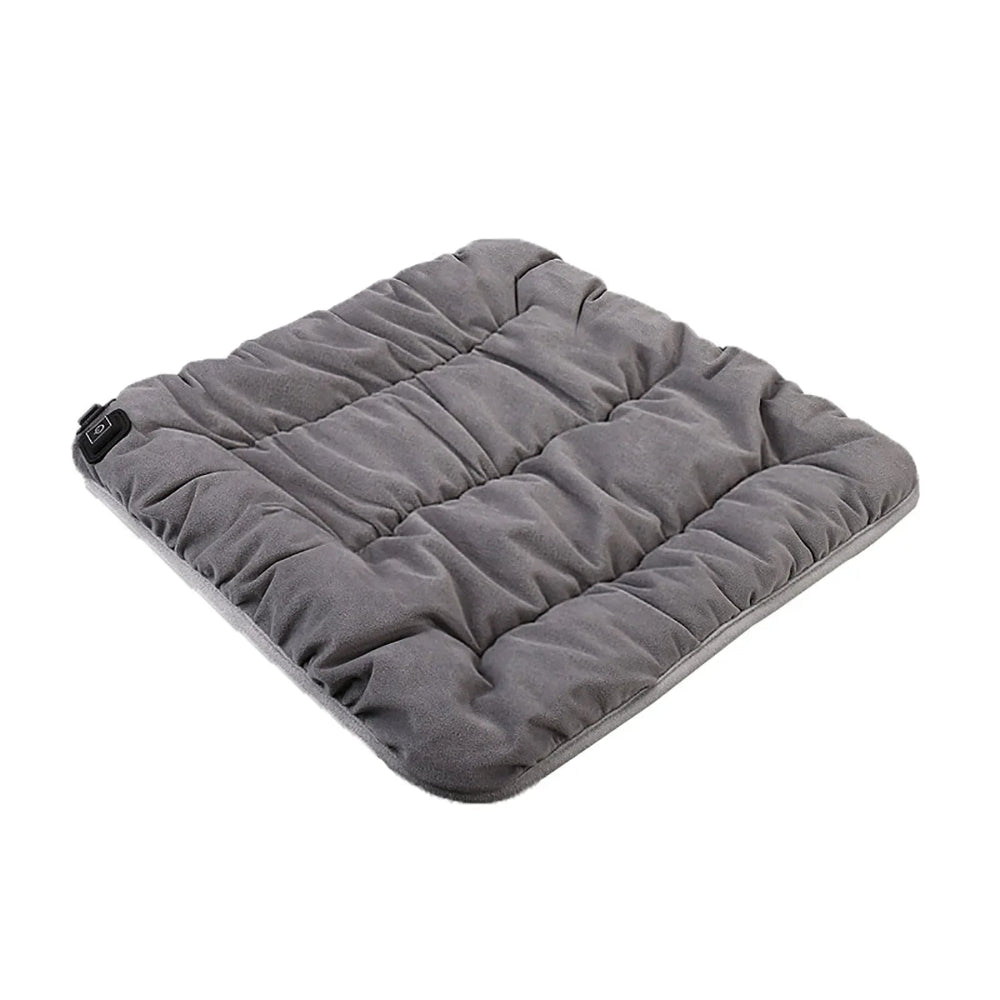 Un coussin chauffant électrique matelassé, posé à plat, avec une surface douce et rembourrée, conçu pour diffuser une chaleur confortable et relaxante.