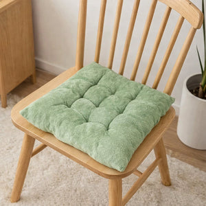 Coussin d’assise antidérapant moelleux gris avec effet capitonné, posé sur une chaise en bois clair dans un intérieur lumineux et chaleureux.