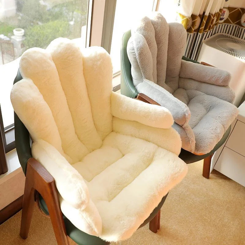 Coussin de chaise décoratif doux et confortable en tissu pelucheux crème et gris, épais et capitonné, installé sur des chaises en bois près d’une fenêtre lumineuse.