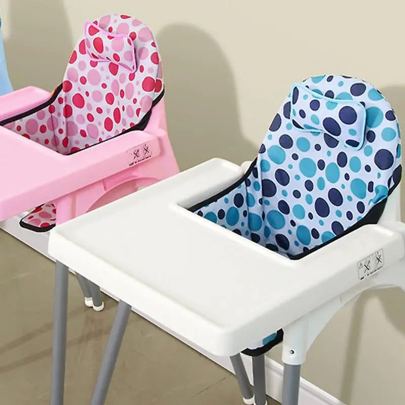 Deux coussins de chaise haute pliables pour bébé installés sur des chaises hautes, avec un design rembourré et des motifs ronds ludiques couvrant le dossier et l’assise.