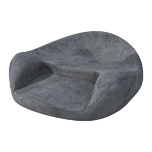 Coussin de sol confortable ergonomique de forme arrondie, avec dossier incurvé intégré et assise épaisse, dans une teinte profonde légèrement texturée, posé sur fond clair.
