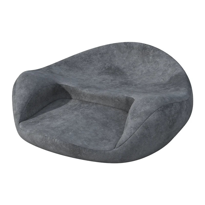 Coussin de sol confortable ergonomique de forme arrondie, avec dossier incurvé intégré et assise épaisse, dans une teinte profonde légèrement texturée, posé sur fond clair.