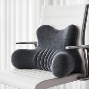 Un coussin orthopédique avec soutien lombaire installé sur une chaise, avec une forme ergonomique sculptée conçue pour soutenir le bas du dos et améliorer le confort d’assise.
