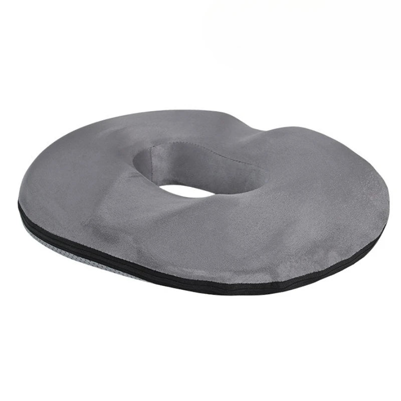 Un coussin orthopédique design moderne avec forme arrondie et ouverture centrale, conçu pour améliorer le confort d’assise sur une chaise ou un fauteuil.