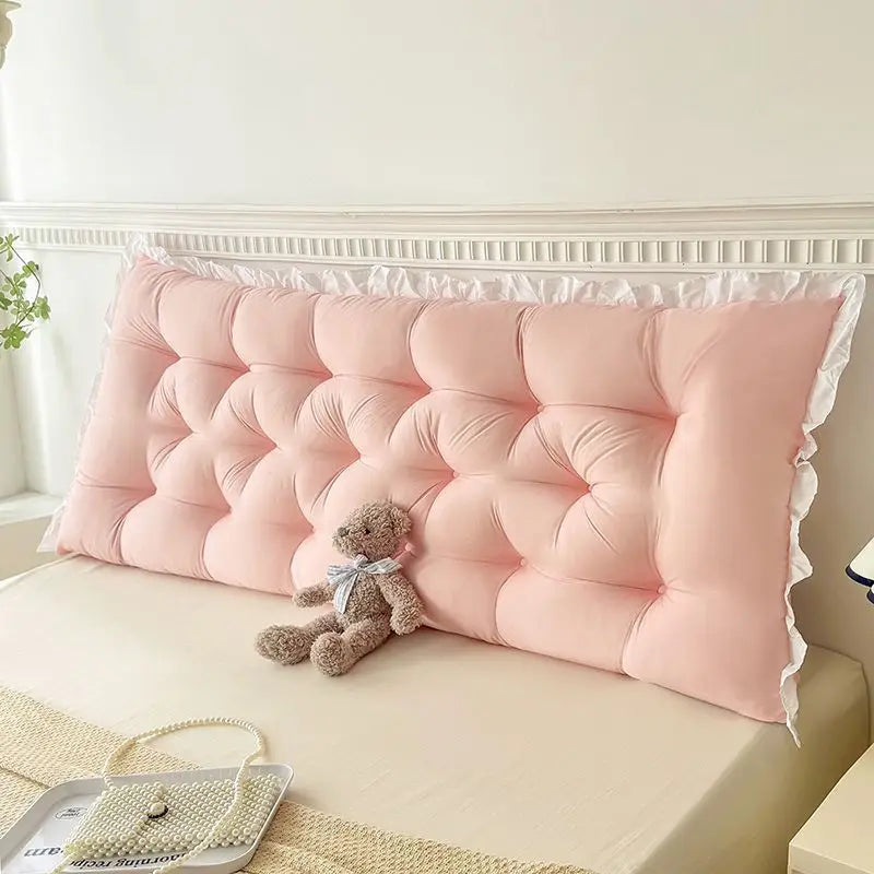 Coussin tête de lit style coréen design minimaliste avec capitonnage profond et contour légèrement volanté, installé sur un lit dans une chambre lumineuse à l’ambiance douce.