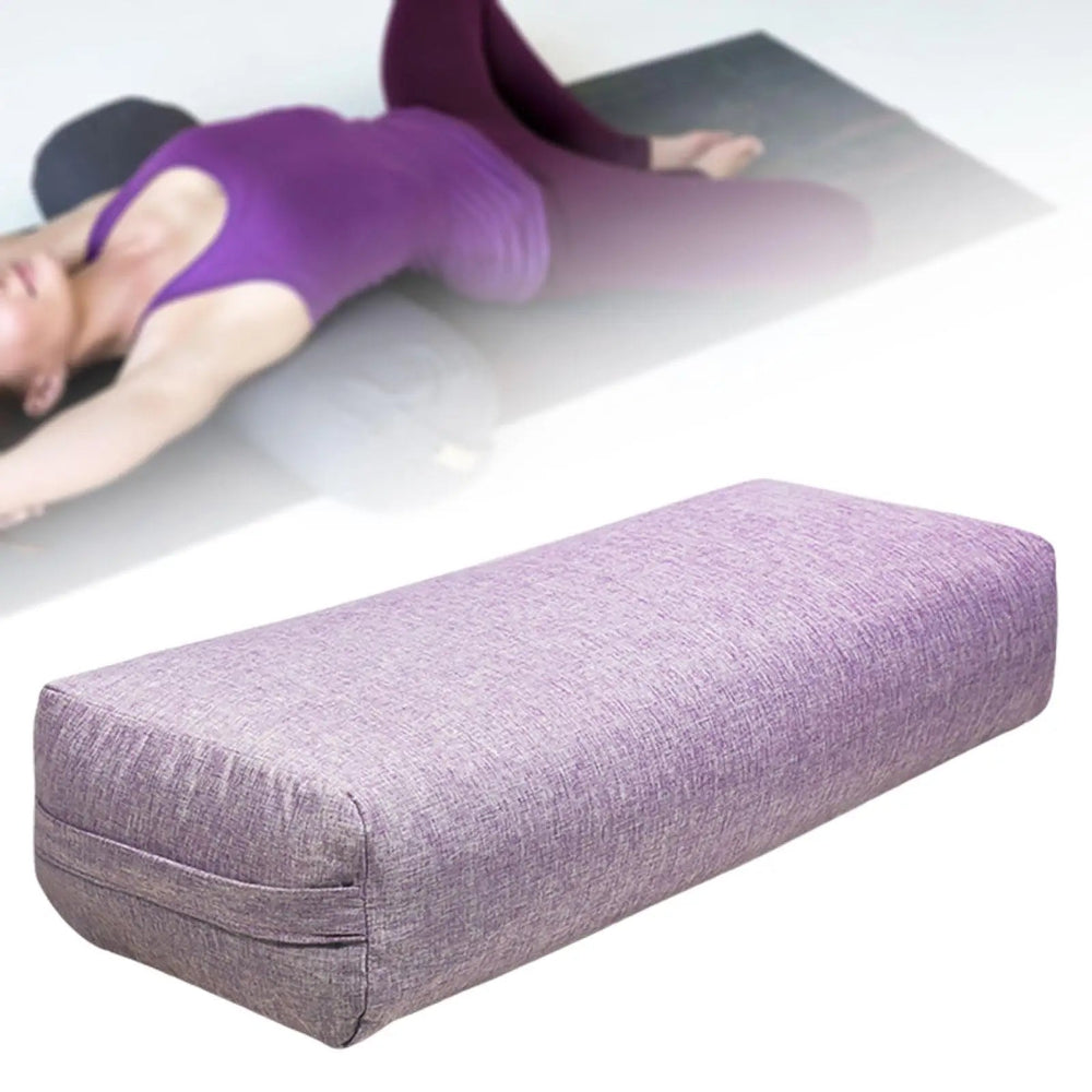 Un coussin yoga doux et confortable de forme allongée posé sur un tapis, utilisé pour soutenir le corps pendant des exercices de yoga et d’étirement.