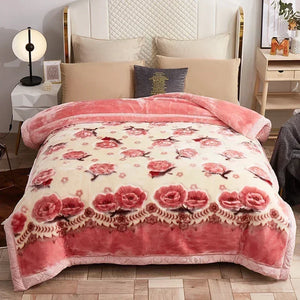 Une couverture lestée avec bordure travaillée et motifs floraux détaillés, disposée sur un lit élégant avec coussins assortis, créant une ambiance chaleureuse et apaisante dans une chambre raffinée.