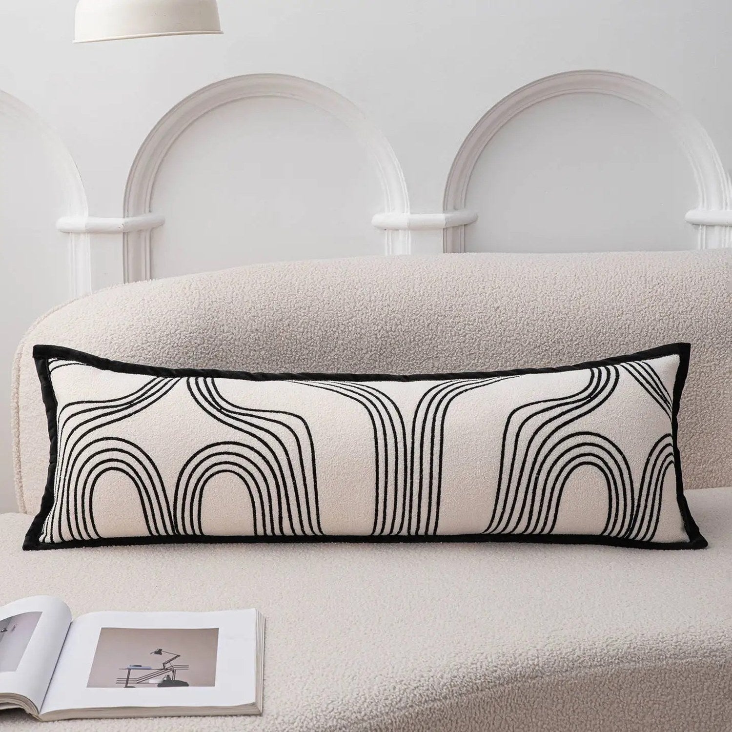 Photo du traversin motif arches noires sur canapé bouclette beige