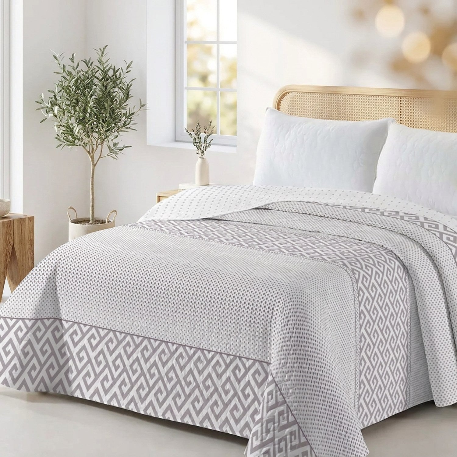 Jeté de lit réversible à motif grec gris sur un lit dans une chambre lumineuse