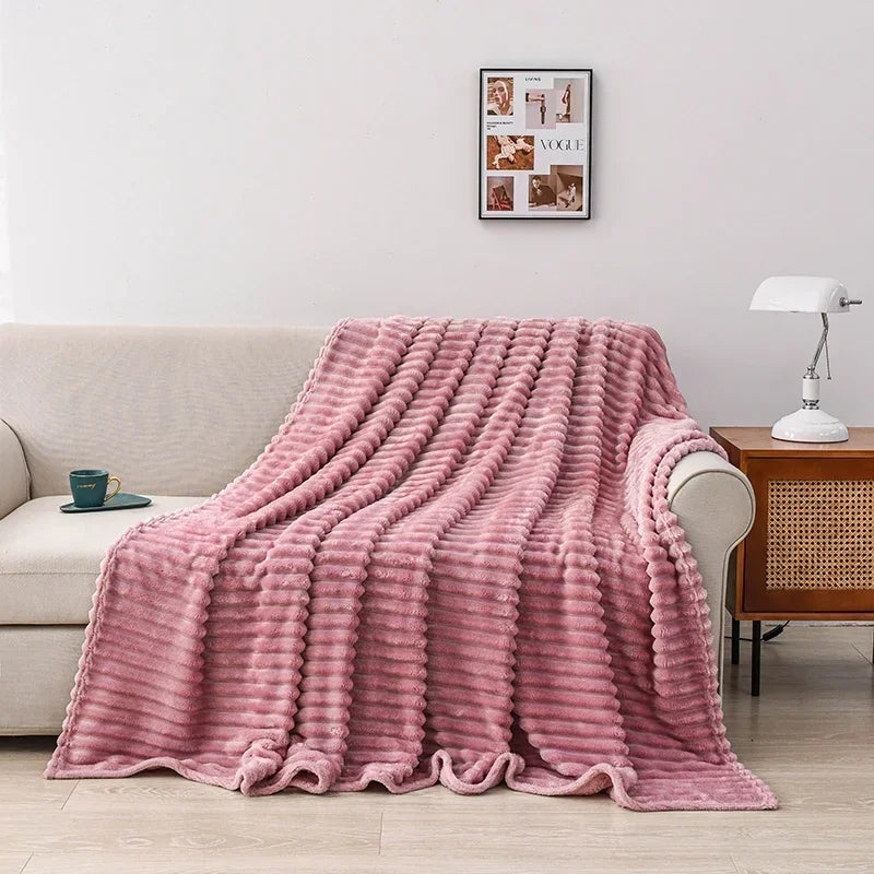 Un grand plaid au relief texturé drapé sur un canapé, avec une surface gaufrée douce et épaisse, créant une ambiance chaleureuse et confortable dans un salon lumineux.
