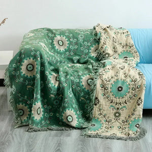 Un grand plaid style japonais double-face drapé sur un canapé, avec motifs circulaires et floraux inspirés de l’art japonais, créant une ambiance douce et élégante dans un salon lumineux.