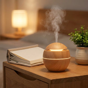 Diffuseur d'arômes effet bois sur une table de chevet avec un livre et une plante