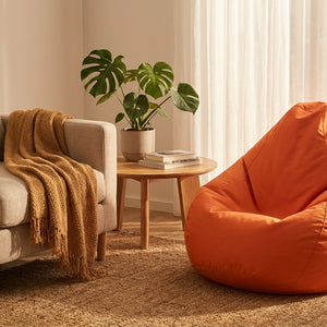 Pouf poire orange dans un salon cosy avec canapé et plante