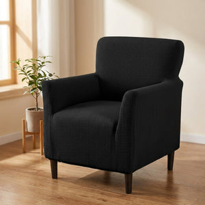 Fauteuil habillé d'une housse jacquard noire dans un salon lumineux