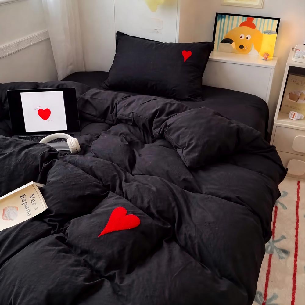 Parure de lit cœur brodé minimaliste avec petit cœur brodé sur la taie d’oreiller et la housse de couette, présentée dans une chambre cosy avec literie moelleuse et ambiance chaleureuse.