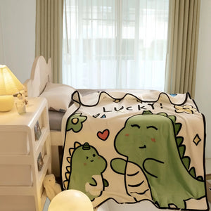 Un plaid bébé avec motifs de petits dinosaures verts et dessins ludiques, posé sur un lit d’enfant dans une chambre lumineuse et apaisante.