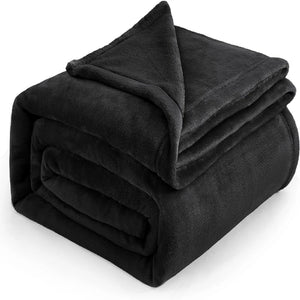 Un plaid cocooning effet peluche plié avec une texture douce et duveteuse, idéale pour créer une ambiance chaleureuse dans le salon ou la chambre.