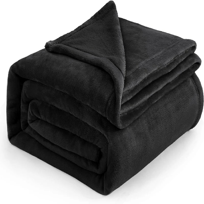 Un plaid cocooning effet peluche plié avec une texture douce et duveteuse, idéale pour créer une ambiance chaleureuse dans le salon ou la chambre.