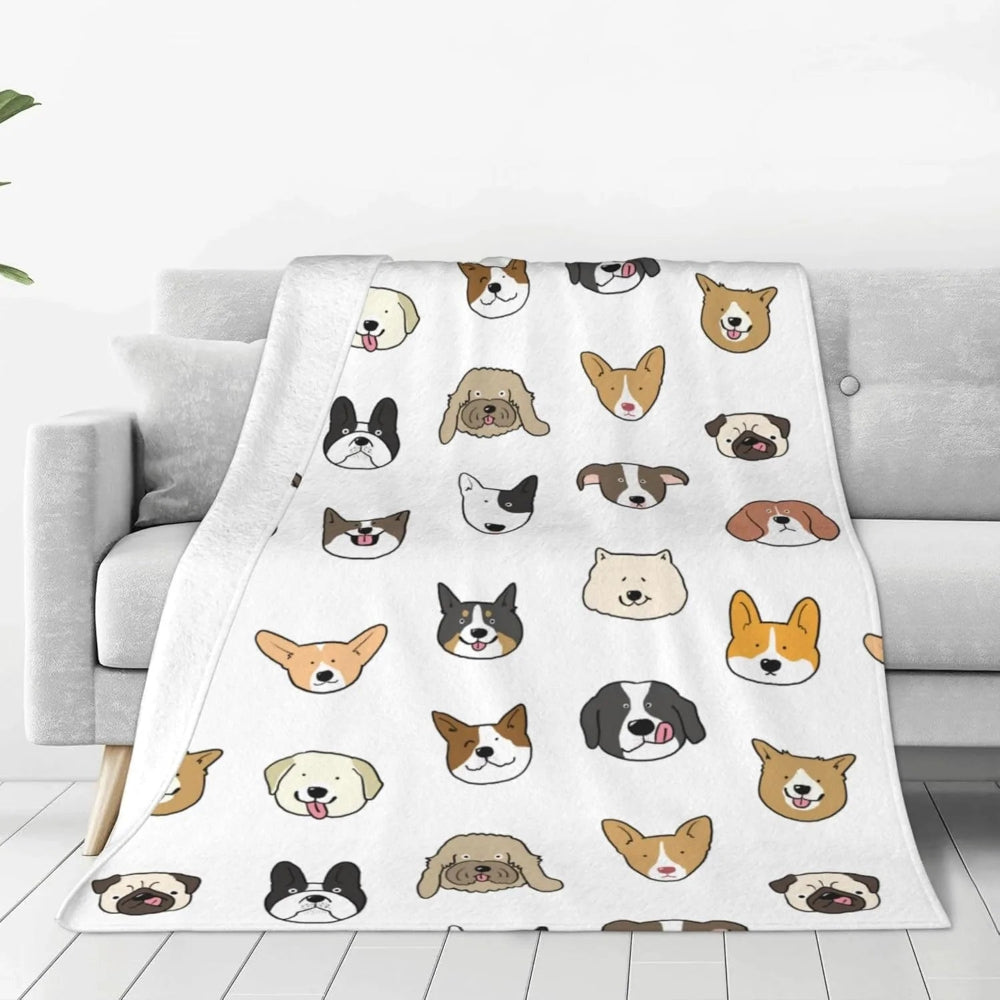 Un plaid enfant à motif animaux avec des visages illustrés répétés, délicatement posé sur un canapé, créant une ambiance douce et ludique dans un salon.
