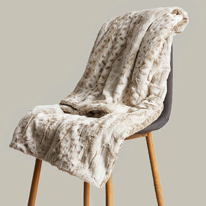 Un plaid léopard en fausse fourrure drapé sur une chaise, avec une texture duveteuse et un rendu élégant, parfait pour une ambiance chaleureuse.