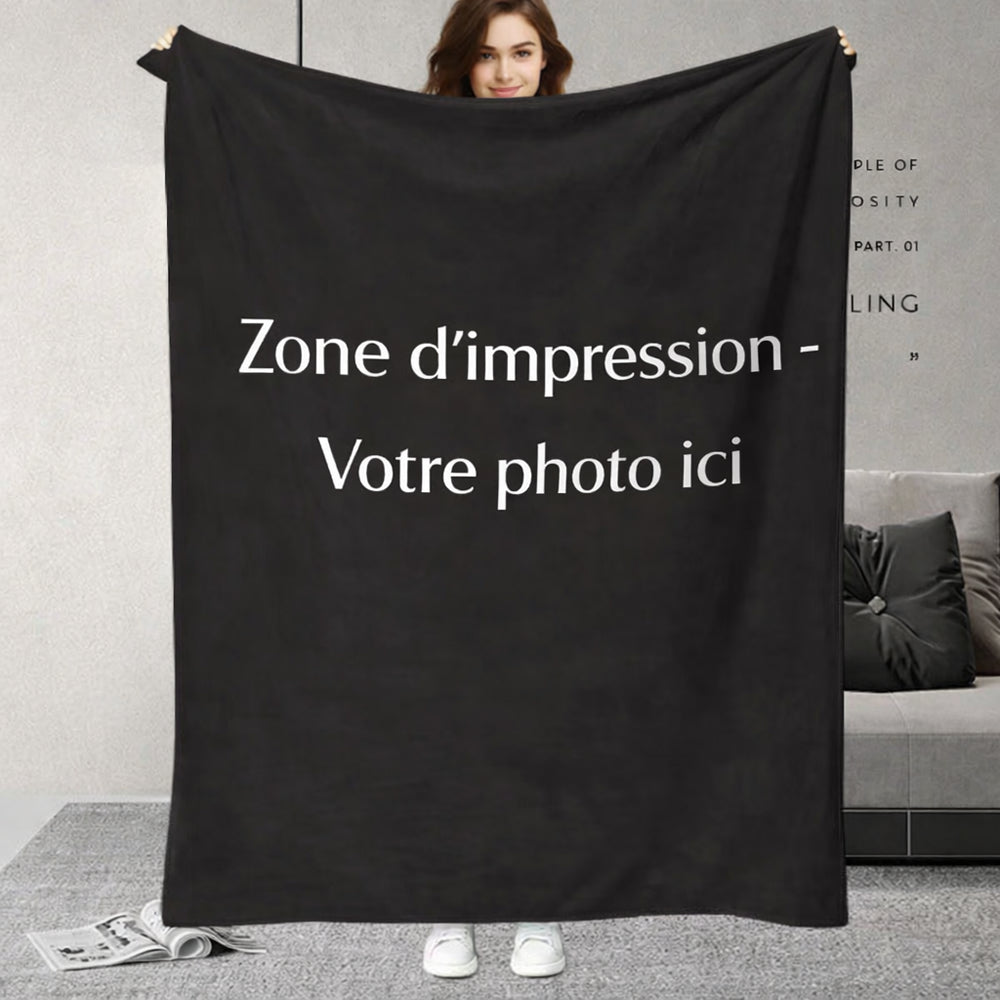 Une personne tient un plaid personnalisé photos avec une grande zone d’impression centrale destinée à accueillir une image, présenté dans un intérieur moderne et épuré.