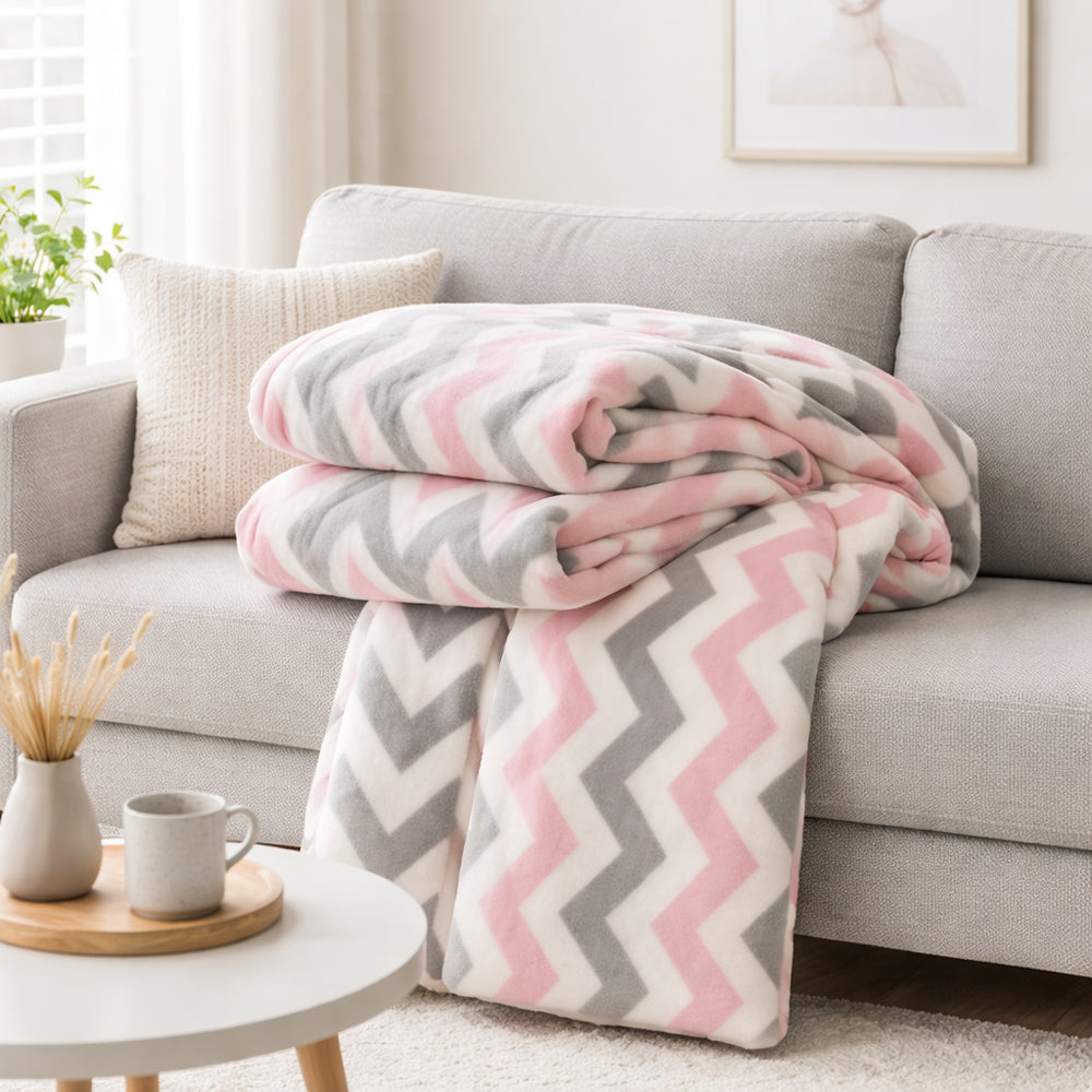 Un plaid polaire motif chevron aux lignes graphiques, créant une ambiance douce et confortable dans un salon lumineux.