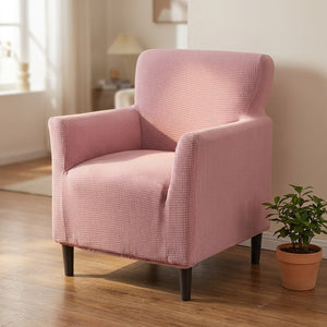 Fauteuil habillé d'une housse jacquard rose dans un salon lumineux